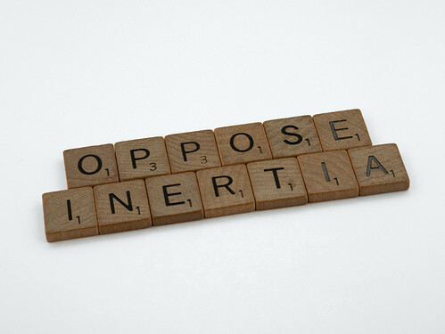 Oppose inertia written in Scrabble tiles